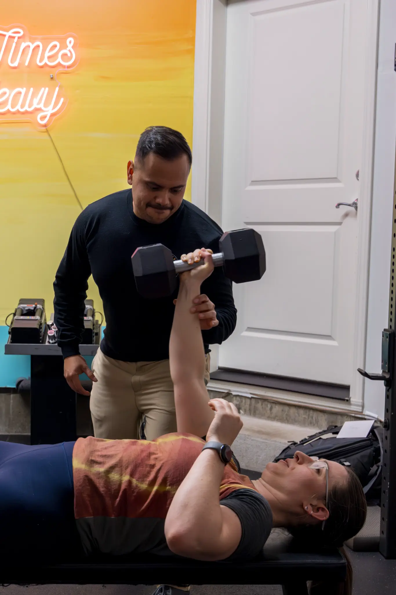 Coach guiding an Above The Barr member during a strength exercise